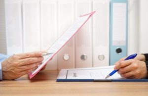 Two people look over forms before signing.