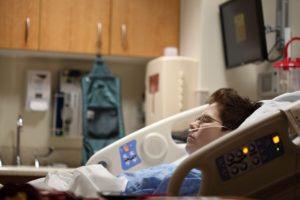 A woman lies in a hospital bed