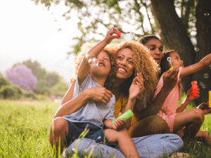 family blowing bubbles in a green field